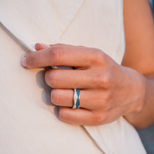 Laden Sie das Bild in den Galerie-Viewer, Nahaufnahme eines Fingers mit dem Ring „Strandwellen“ aus poliertem 925er Silber, gefüllt mit Strandsand® und blauem Steinsand