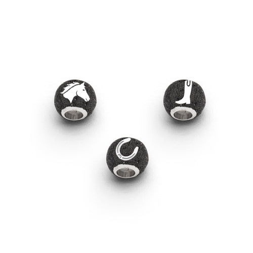 Strandsandkugel „Pferdeglück“ von DUR Schmuck mit Pferdekopf, Hufeisen und Reitstiefel, eingebettet in schwarzem Lavasand, gefasst in rhodiniertem 925er Sterling-Silber
