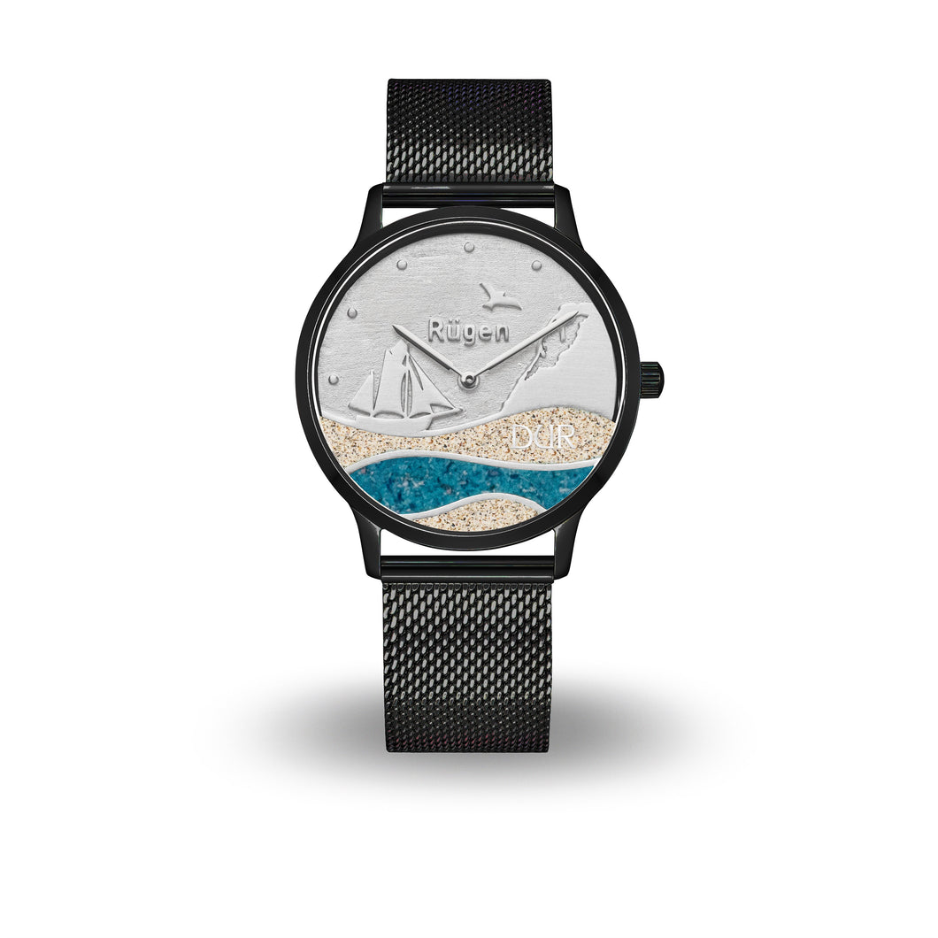 Schwarze DUR Uhr „Strandwellen Rügen“ mit Ziffernblatt aus echtem Strandsand und Kyanit, Motiv mit Wellen, Schiff, Kreidefelsen, Möwe & „Rügen“-Schriftzug, 36 mm, Edelstahl Meshband