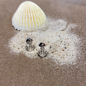 Ohrstecker "Sandanker" von DUR Schmuck, Strandsand Ohrringe hier aus Strandsand vor einer Muschel auf braunem Grund dekoriert